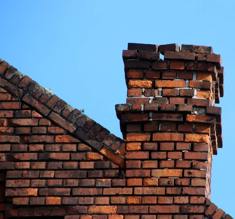 Damaged chimney on an San Marcos home showing cracks and missing mortar